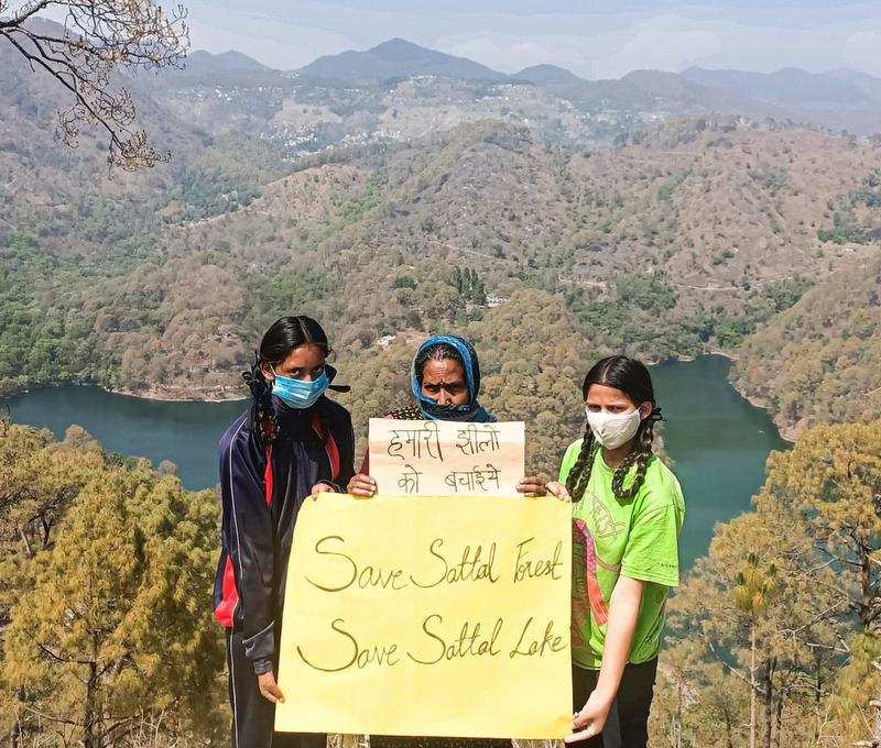 Local residents with a poster protesting against proposed construction in Sattal