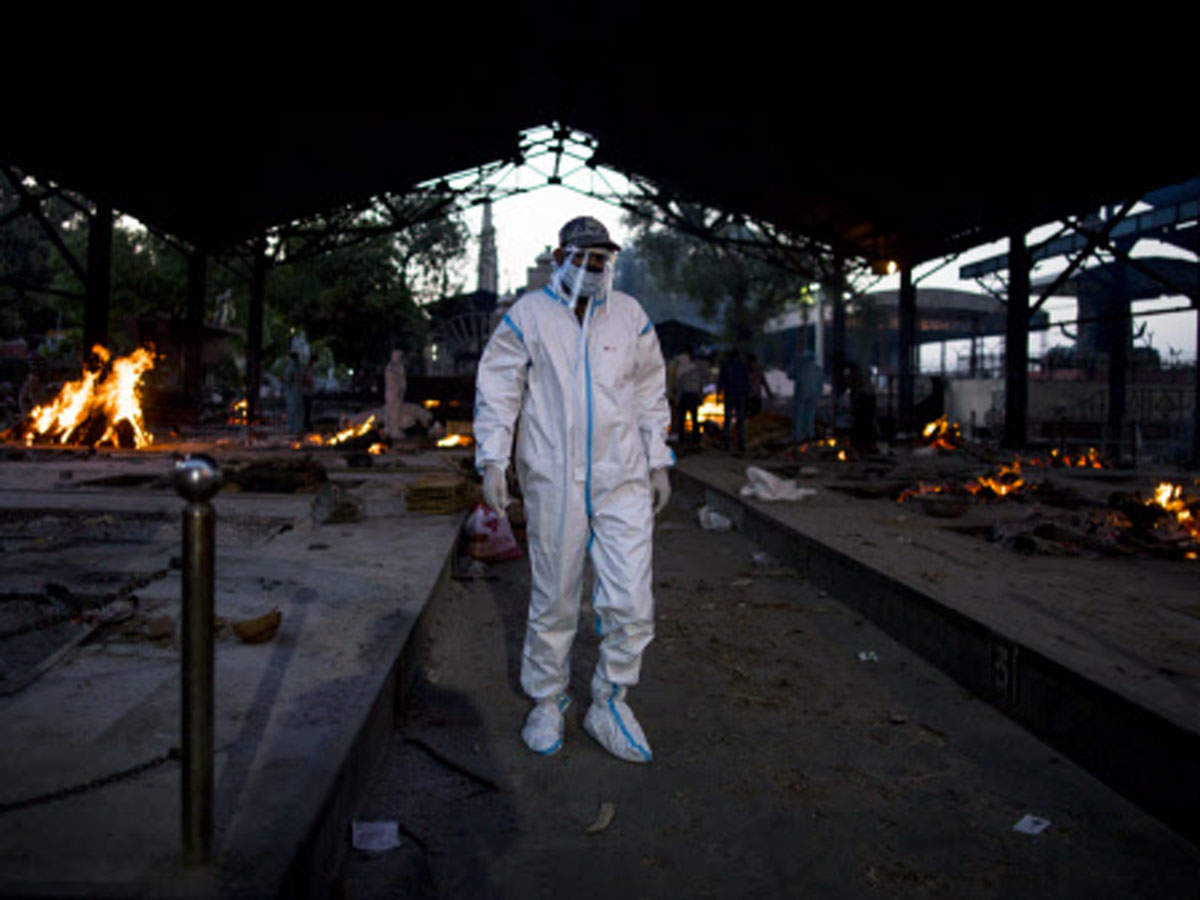 A man wearing PPE suit prepares to perform the last rites of his relative near multiple burning pyres of patients who died of the Covid-19 infection at a crematorium in New Delhi on April 17. (Getty Images)