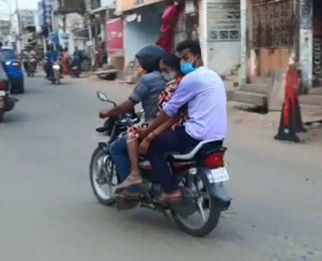 A screenshot of a video shows the woman's body being carried on a motorbike in Palasa town.