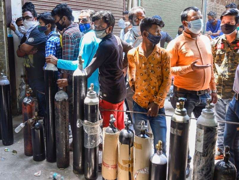 Family members of COVID-19 patients wait outside an oxygen-filling centre to refill their empty cylinders, in Delhi (PTI)