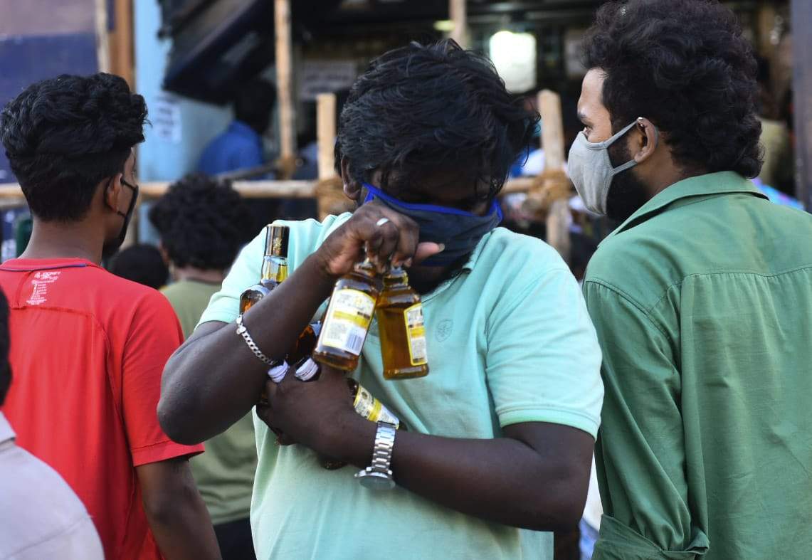 A man leaves a Tasmac shop in Chennai on Sunday with bottles of liquor. Photo by C Suresh Kumar 