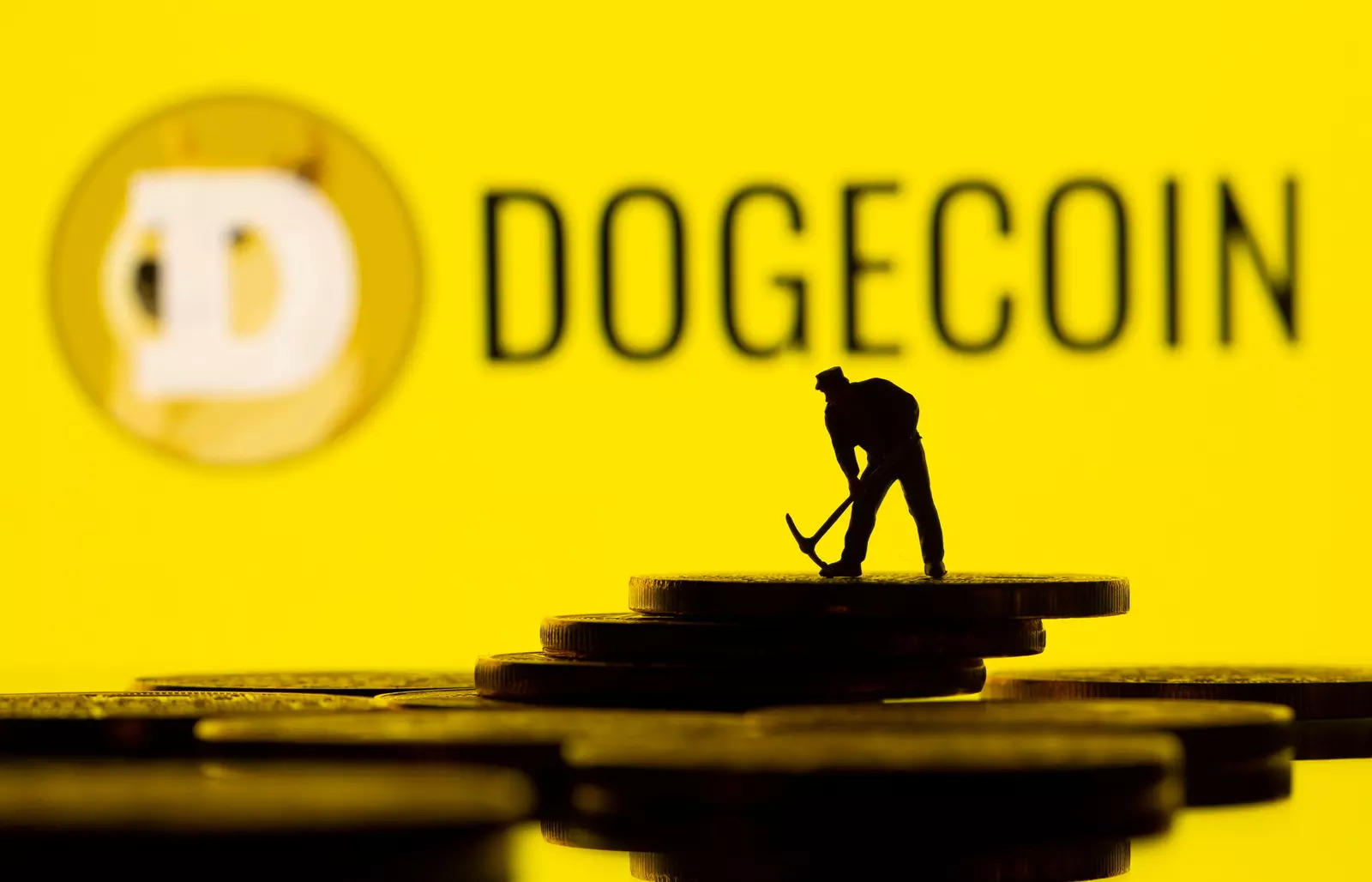 FILE PHOTO: A small toy figure is seen on the cryptocurrency representation with Dogecoin logo in the background in this illustration picture taken, April 20, 2021. (Reuters)