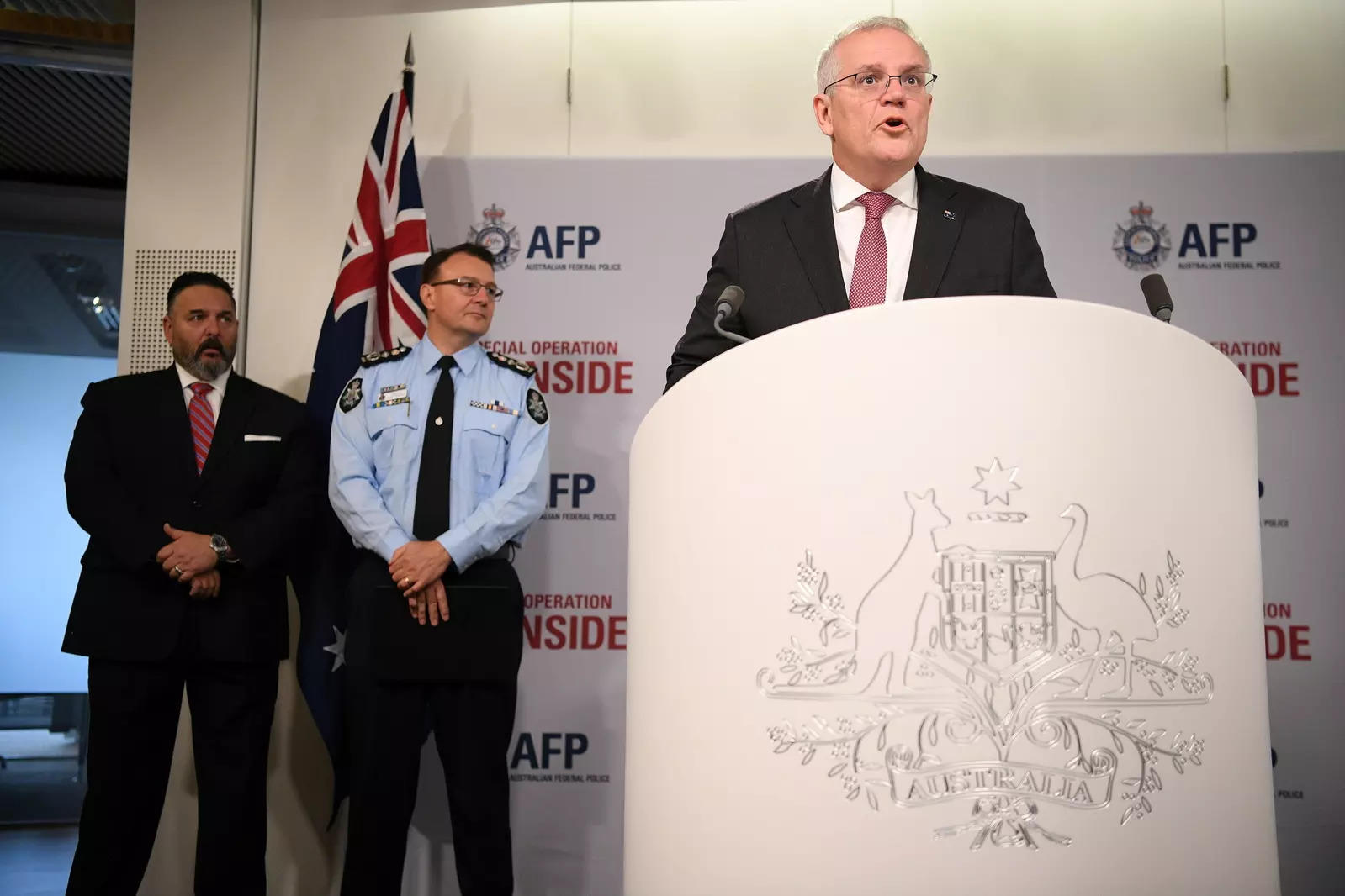 Australian Prime Minister Scott Morrison speaks during a media briefing about Operation Ironside, which disrupted organised crime internationally, as U.S. Embassy's FBI Legal Attaché Anthony Russo, (L) and Australian Federal Police (AFP) Commissioner Reece Kershaw (C) look on in Sydney