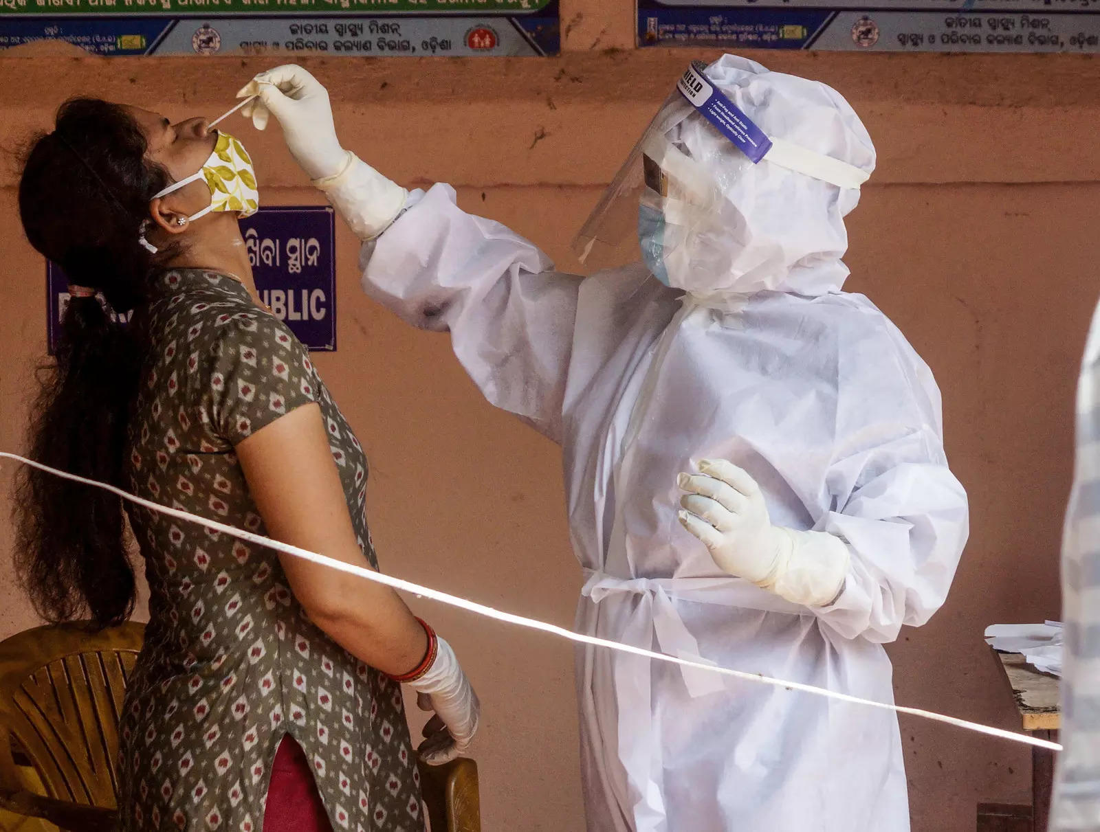 A medic collects nasal swab sample of a woman for COVID-19 test (Picture credit: PTI)