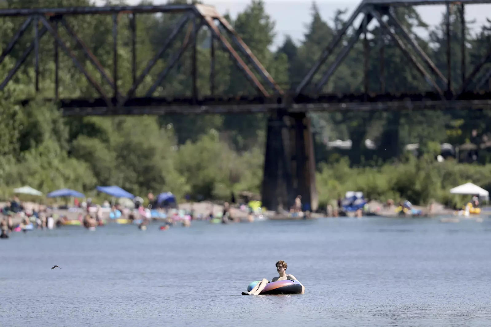 People gather at the Sandy River Delta, in Ore., to cool off during the start of what should be a record-setting heat wave. (AP)