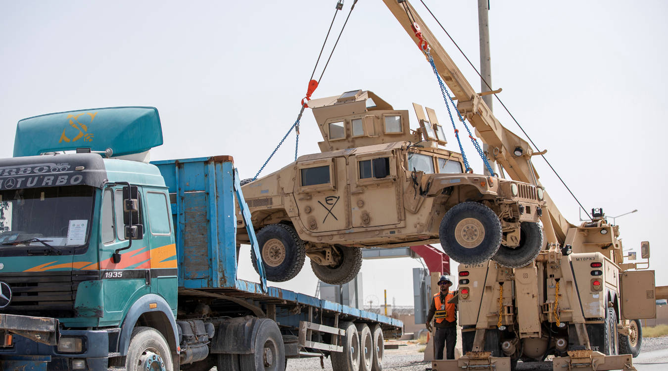 US Army soldiers and contractors load High Mobility Multi-purposed Wheeled Vehicles, HUMVs, to be sent for transport as US forces prepare for withdrawal, in Kandahar, Afghanistan. (Reuters)