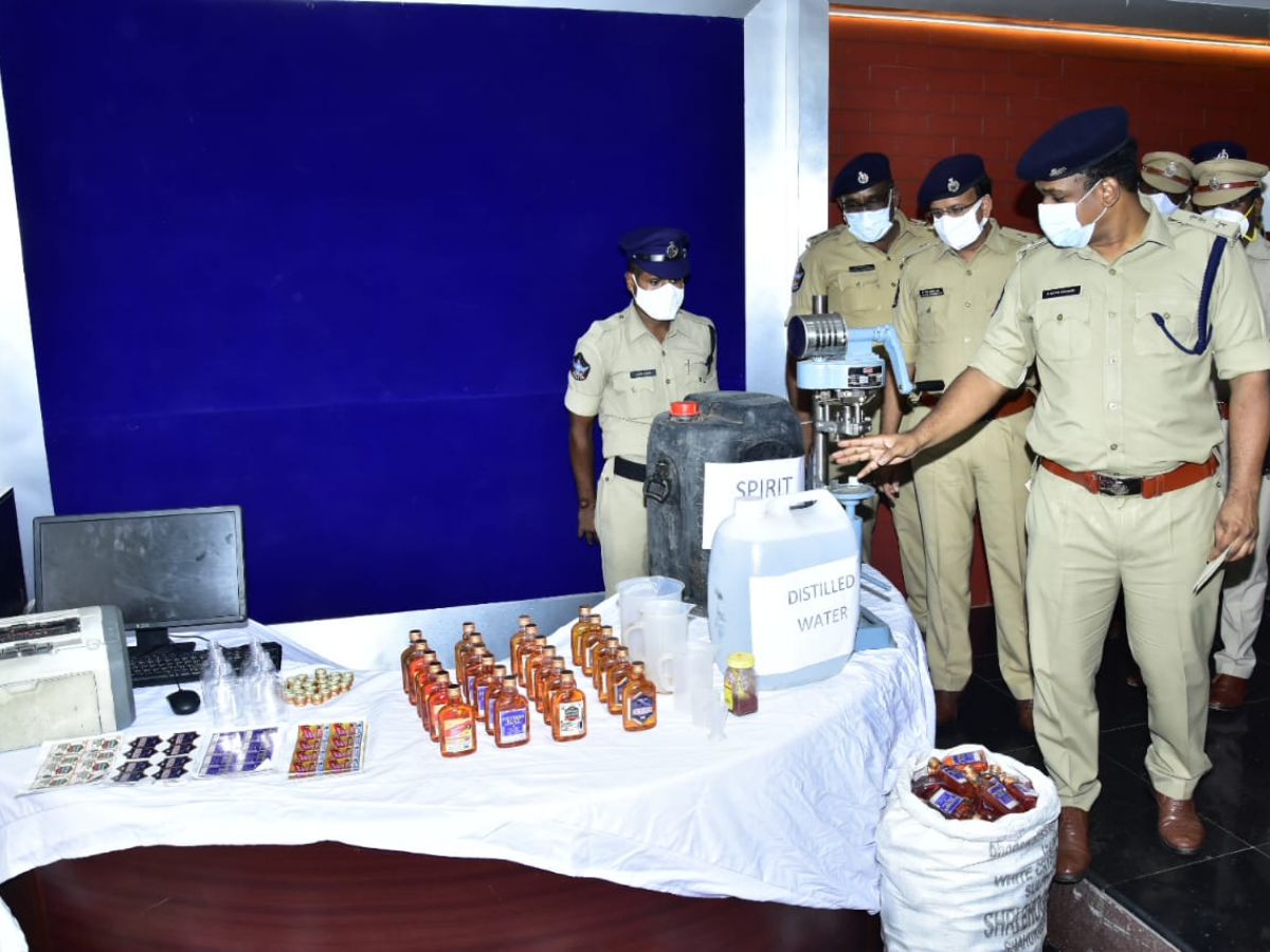 Police seized a cap-sealing machine, 20 litres of spirit, 25 litres of distilled water, brown food colour powders, 30 litres illicit liquor, 791 liquor bottles and other materials from the accused. (TOI Photo)
