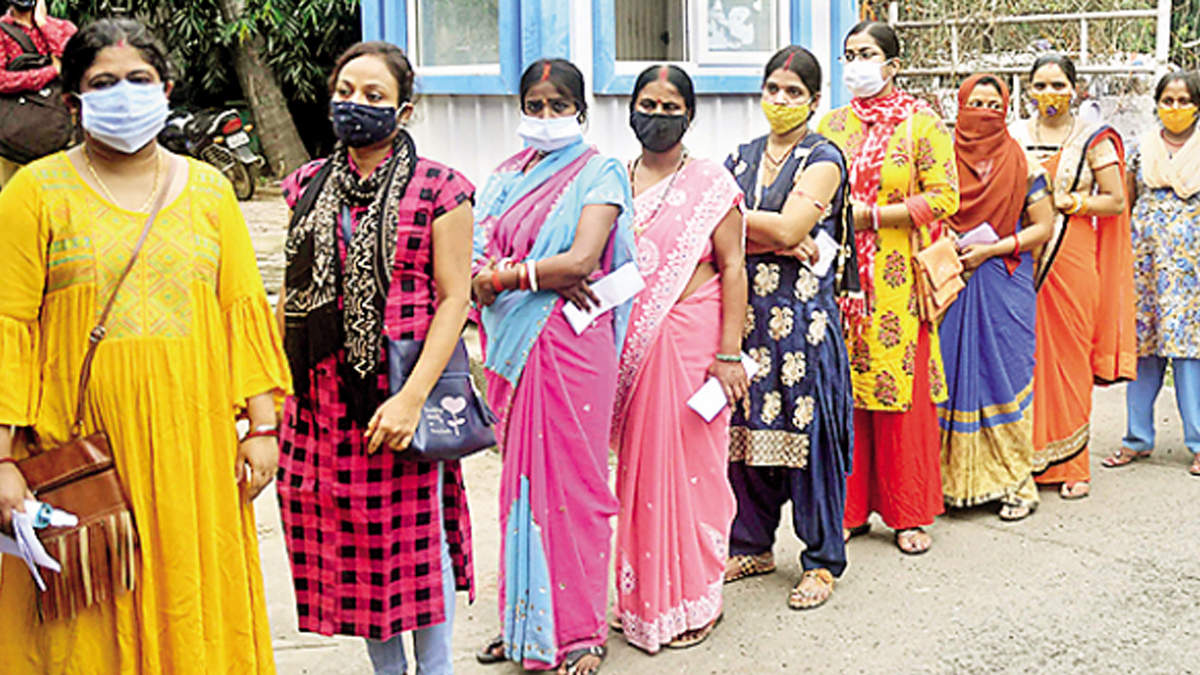 Women wait for their turn to receive Covid vaccine shots in Patna