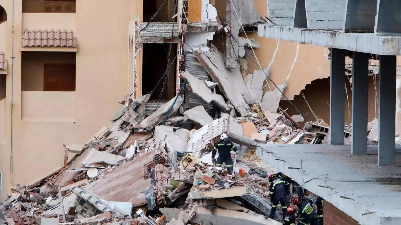 Firefighters work among the debris of a collapsed building in the town of Peniscola, Spain. (Credits: Reuters)