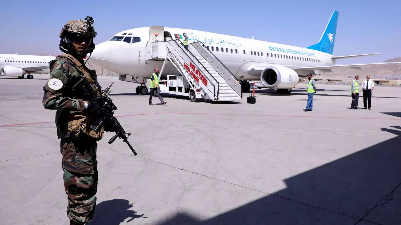 A member of Taliban forces stands guard next to a plane at Hamid Karzai International Airport in Kabul (Reuters)