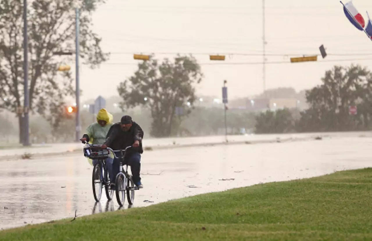 Cyclists make their way down a street in Bay City, Texas as Tropical Storm Nicholas approaches on Monday. (AP photo)