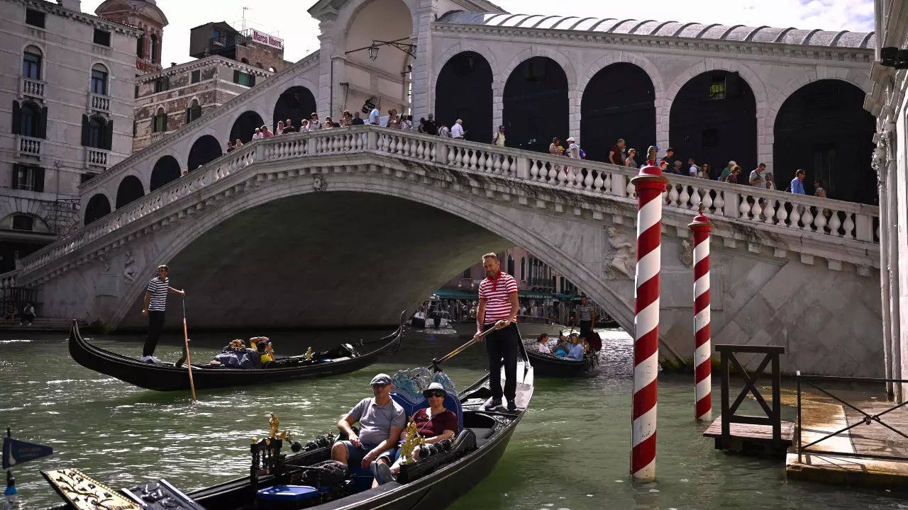 Tourist go for a gondola ride by the 16th-century stone arch Rialto Bridge at the Grand Canal in Venice. (AFP photo)