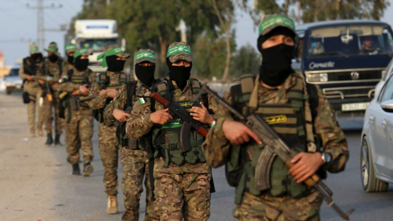 Masked men from the Izzedine al-Qassam Brigades, a military wing of Hamas, march with their weapons along the main road of Nusseirat refugee camp, central Gaza Strip (AP file photo)