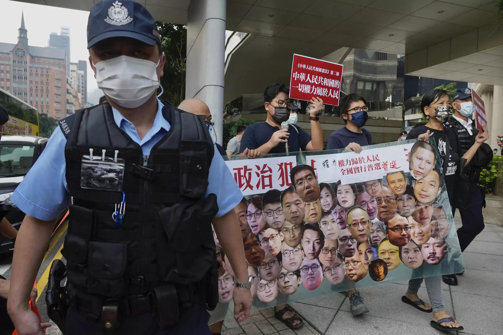 File photo: Pro-democracy protesters march beside a police officer in Hong Kong.