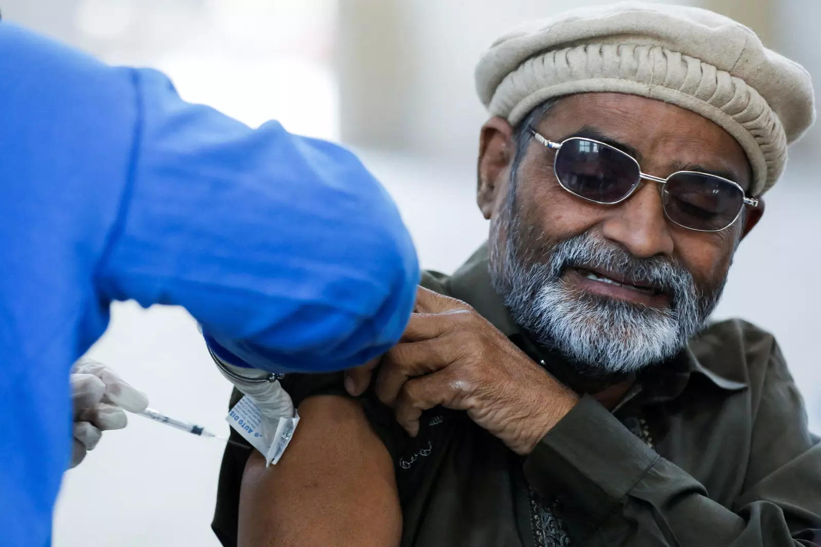 A man receives a dose of coronavirus disease  booster vaccine at a vaccination centre in Karachi