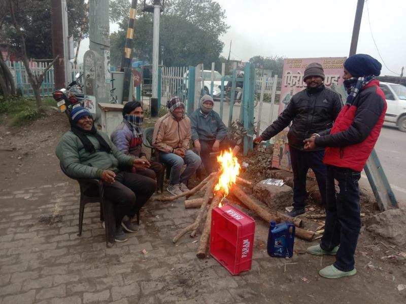 Residents of US Nagar gather around a bonfire. Due to severe cold and reduced visibility, traffic has reduced to half in the district