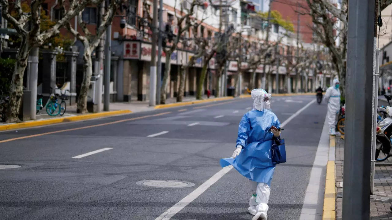 A worker in a protective suit keeps watch on a street, as the second stage of a two-stage lockdown to curb the spread of Covid begins in Shanghai. (Reuters photo)