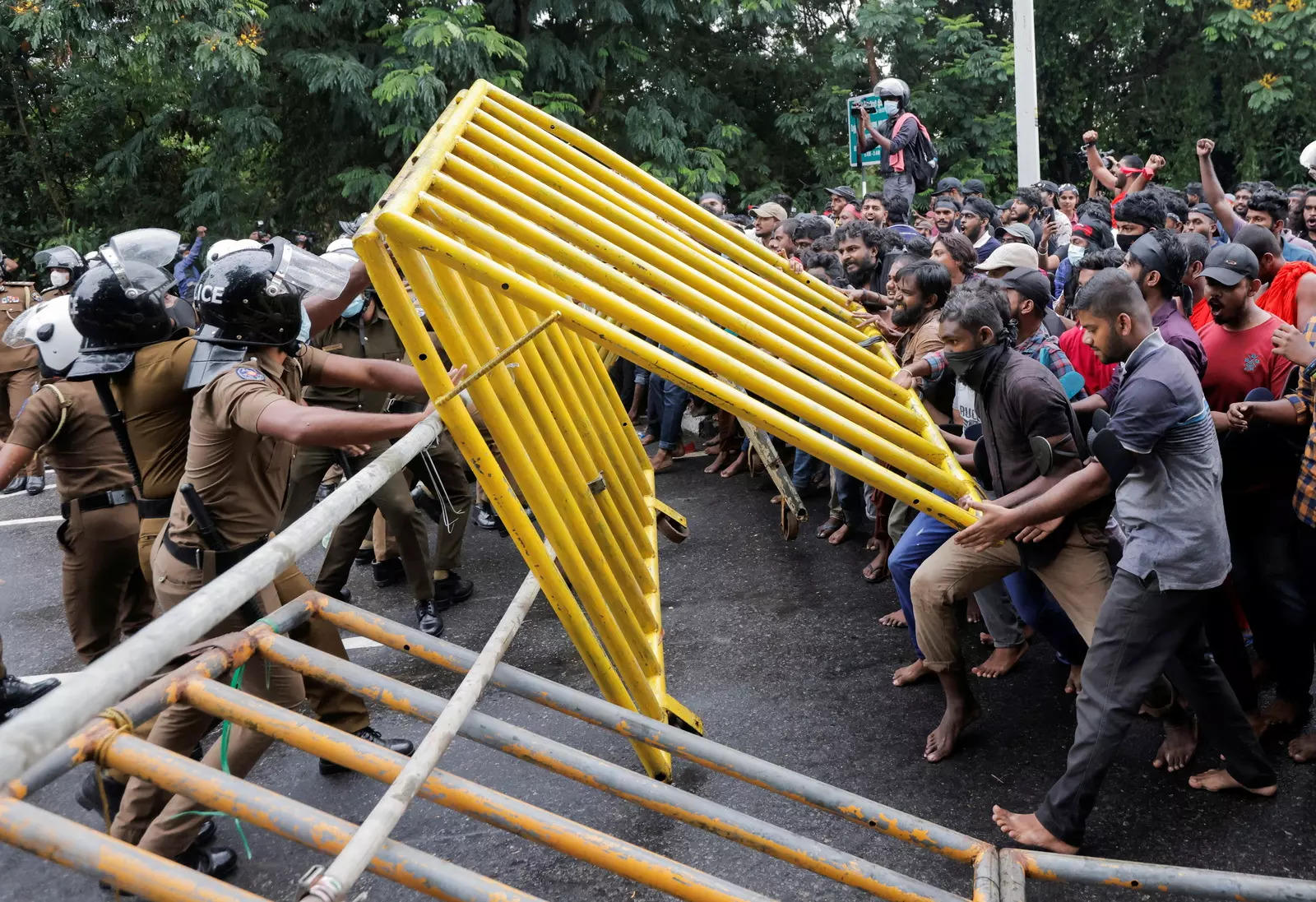 Demonstrators pull down metal barriers as they try to enter the main road towards the parliament during a protest against Sri Lankan President Gotabaya Rajapaksa near the parliament.