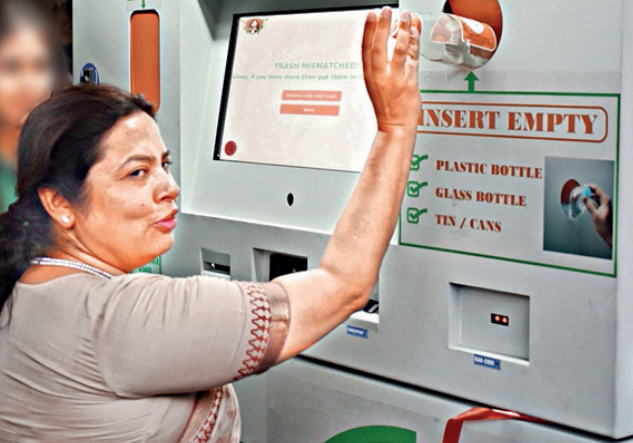 Union minister Meenakshi Lekhi tries out a reverse vending machine in Delhi
