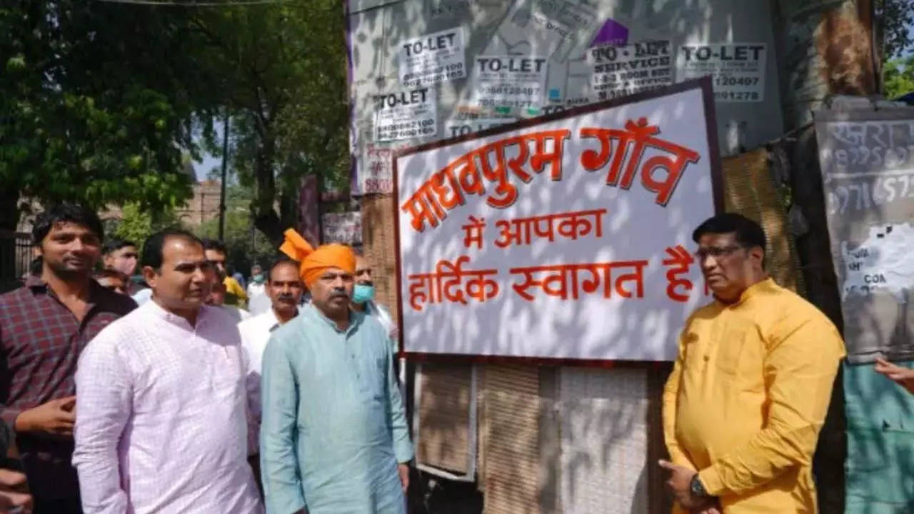 BJP's Delhi unit president Adesh Gupta also posed with workers and locals in front of a freshly painted board that welcomed visitors to 'Madhavpuram'