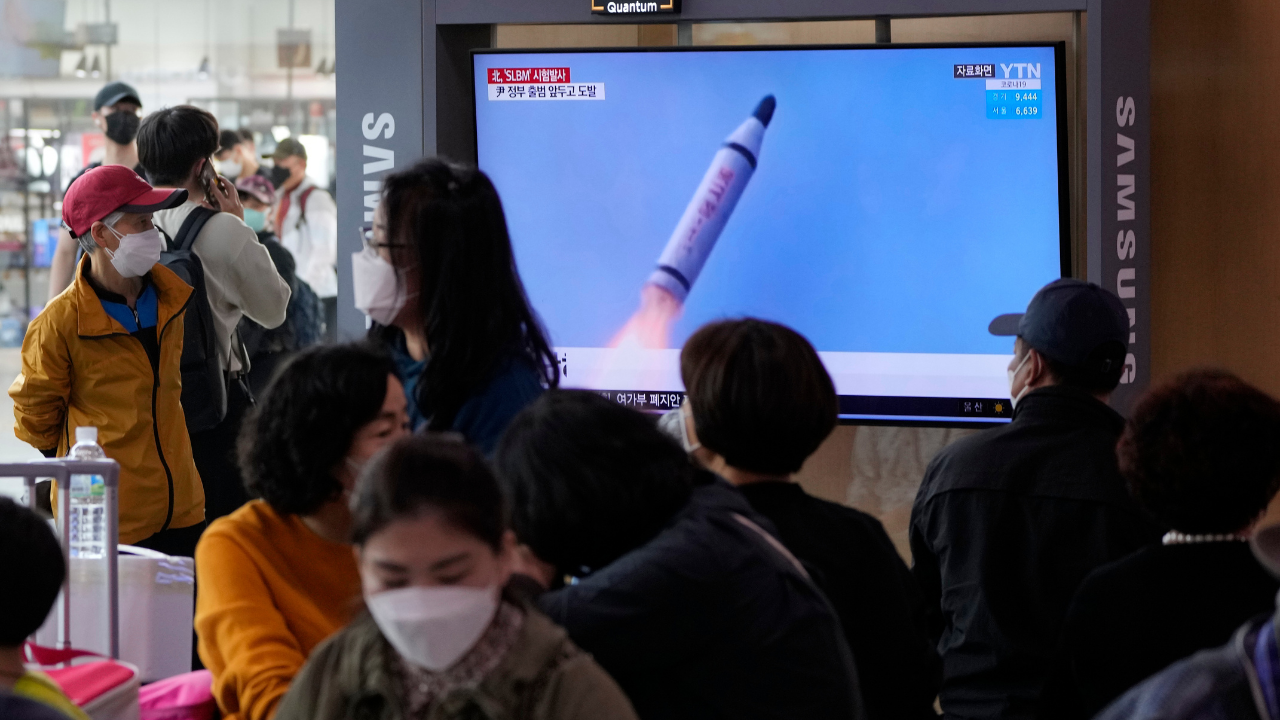 People watch a TV showing a file image of North Korea's missile launch during a news program (AP)