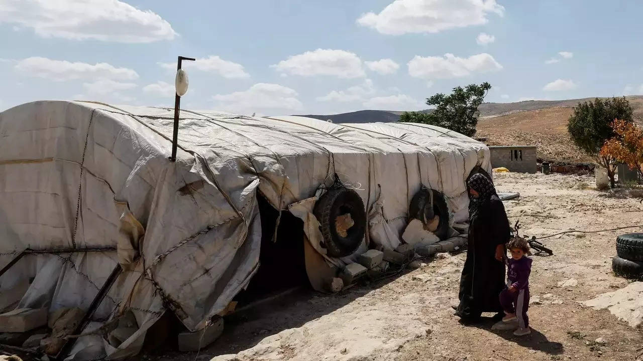 Palestinian walks in front of her tent, in Masafer Yatta (Credit: Reuters)