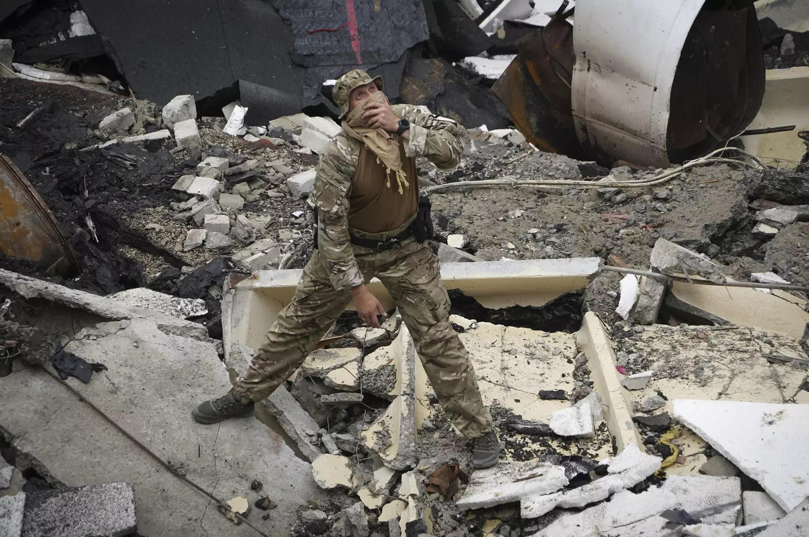A Ukrainian serviceman looks at the ruins of the sports complex of the National Technical University in Kharkiv, Ukraine