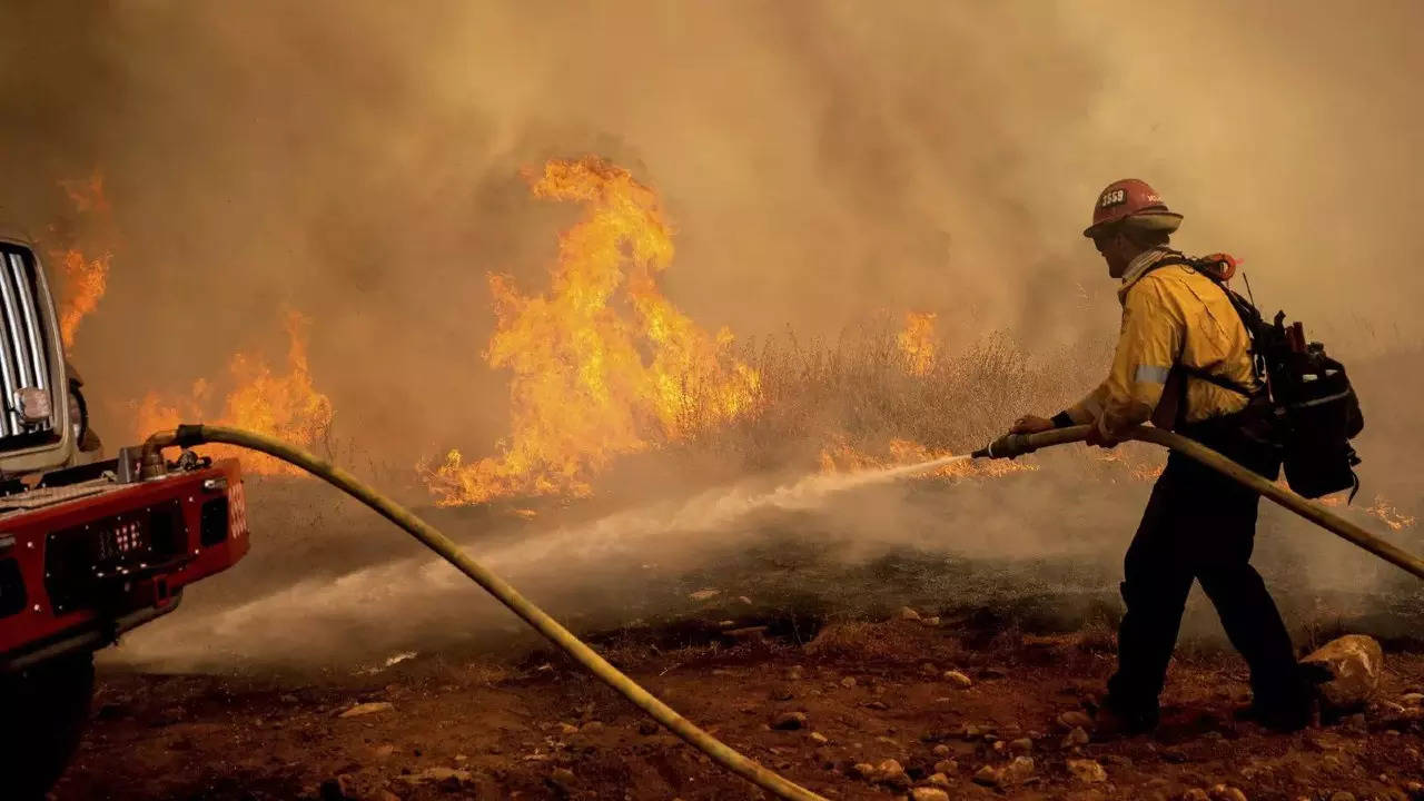 A firefighter sprays water while trying to keep the Electra Fire from spreading (File photo: AP)