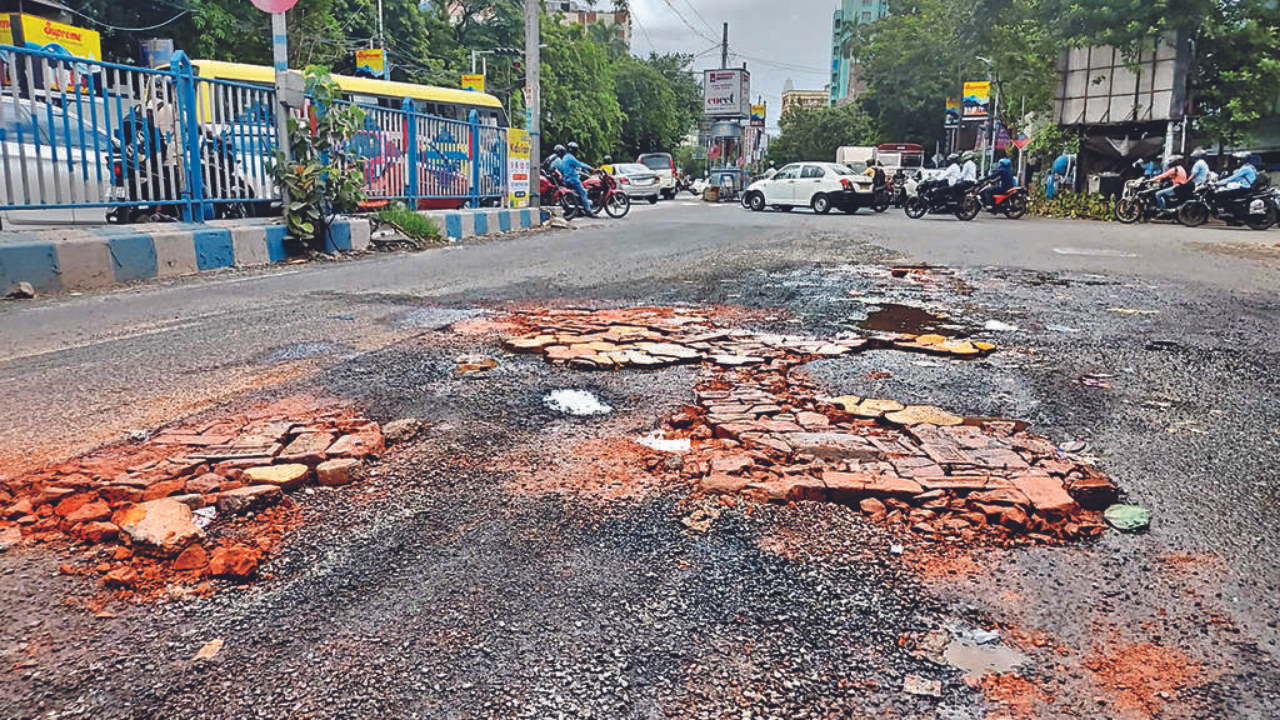The craters on Gariahat Road have been temporarily filled up with bricks, but it is still slowing traffic flow, especially during rush hours