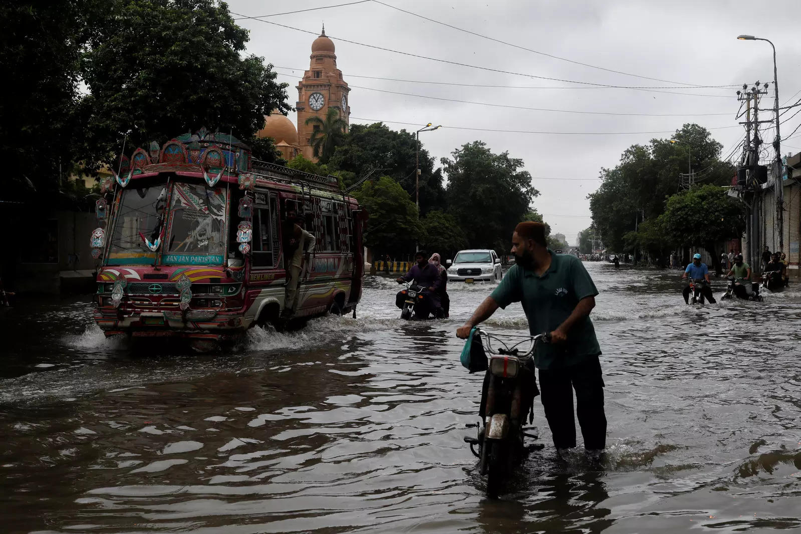 Residents commute through a flooded street, following heavy rains during the monsoon season in Karachi 