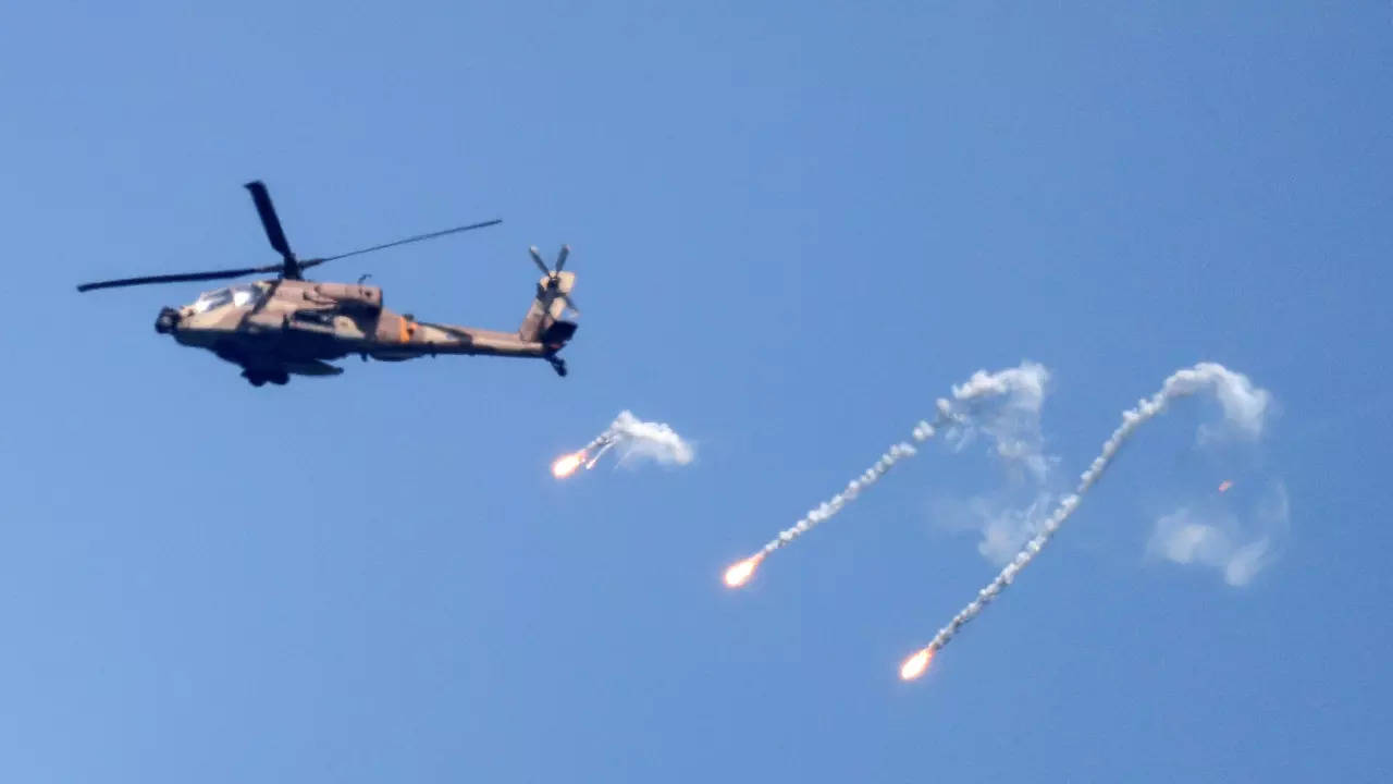 An Israeli Air Force Apache helicopter fires flares in the sky above the Israel-Gaza border (Reuters)
