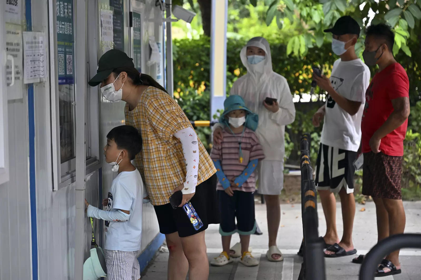 Tourists wearing face masks wait in line to get their Covid-19 test at a coronavirus testing site in Sanya in south China's Hainan Province on Sunday. (AP file photo)