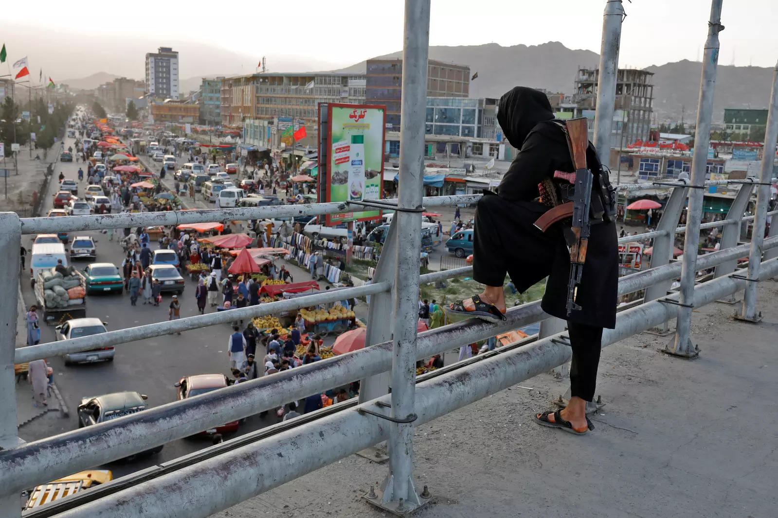 A Taliban fighter stands guard on a bridge in Kabul 