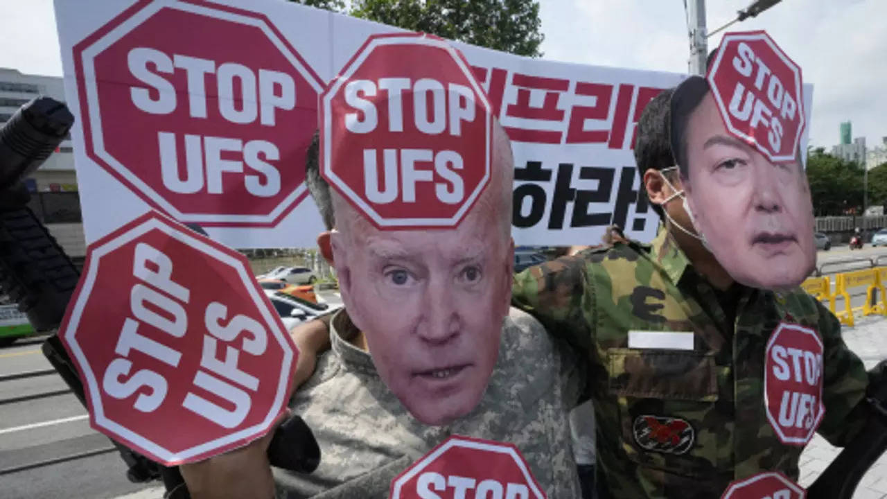 Protesters wearing masks of US President Joe Biden and South Korean President Yoon Suk Yeol stage a rally to oppose planned joint military exercises between South Korea and the United States (AP)