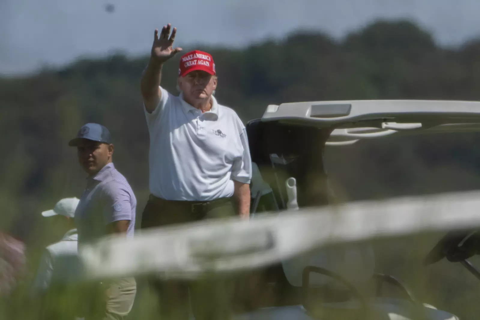 Former President Donald Trump gestures while playing golf at Trump National Golf Club in Sterling.