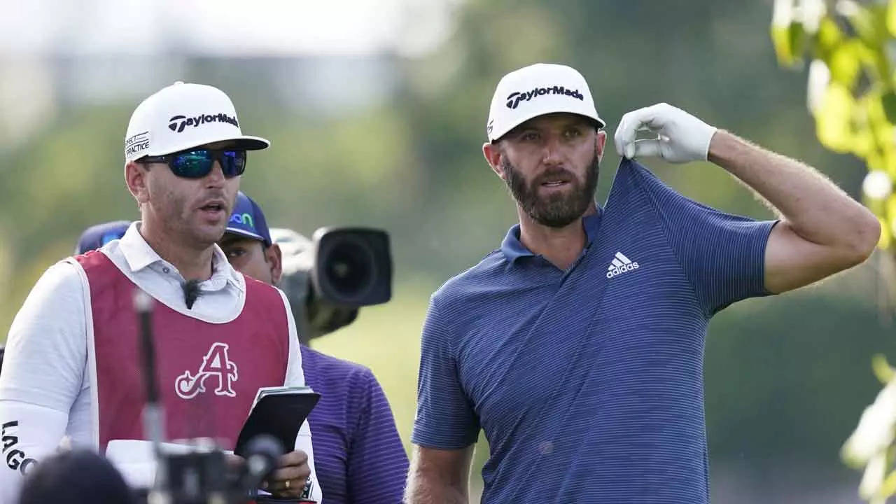 Dustin Johnson tugs on his shirt as he listens to his caddie during the first round of the LIV Golf Invitational-Chicago (AP Photo)