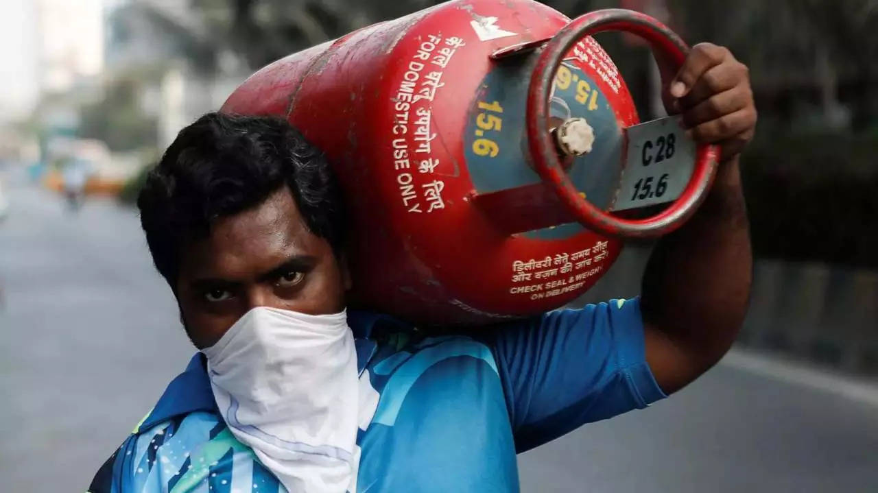 A man carries a gas cylinder in Mumbai as he waits to purchase cooking gas (Reuters)