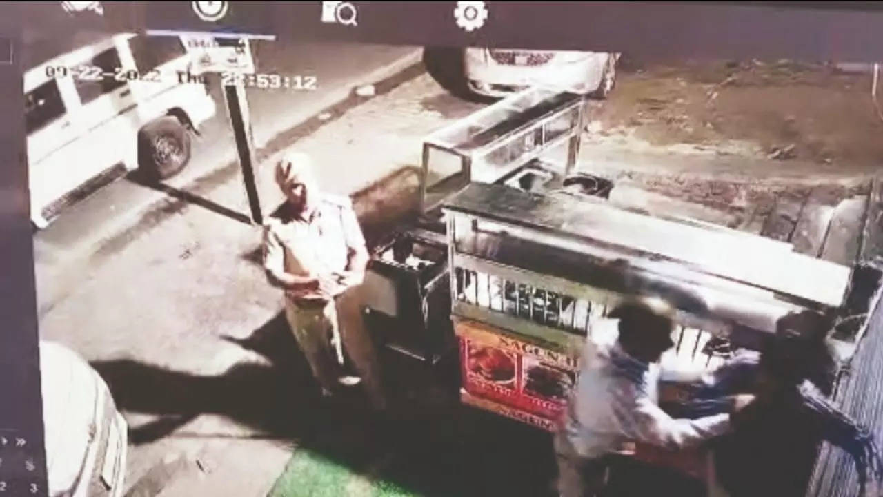 Video grab of ACP North holding the shopkeeper by the collar and pushing him against the shutter of his shop in Ludhiana