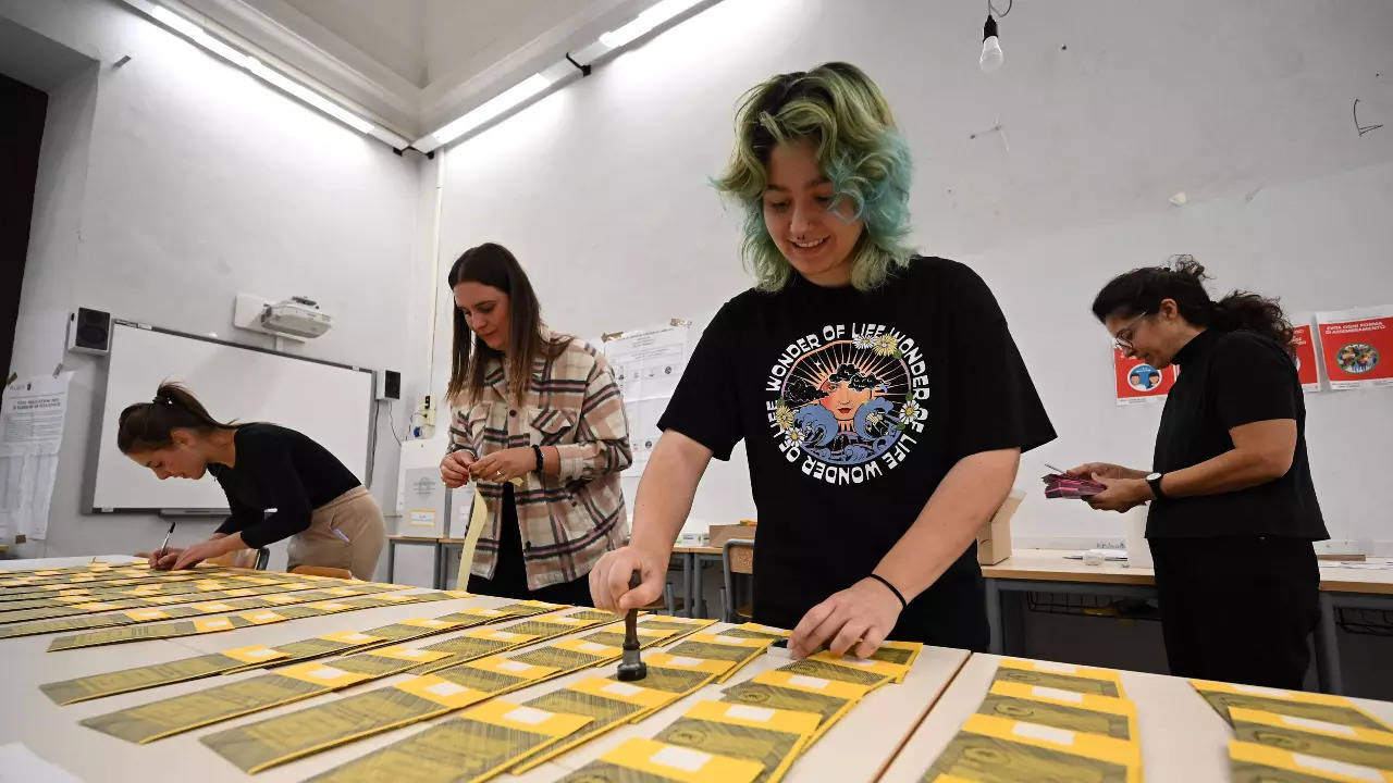 Volunteers prepare yellow ballot papers for the Senate vote, on September 24, 2022 at a polling station in Rome, on the eve of the country's legislative election (AFP)