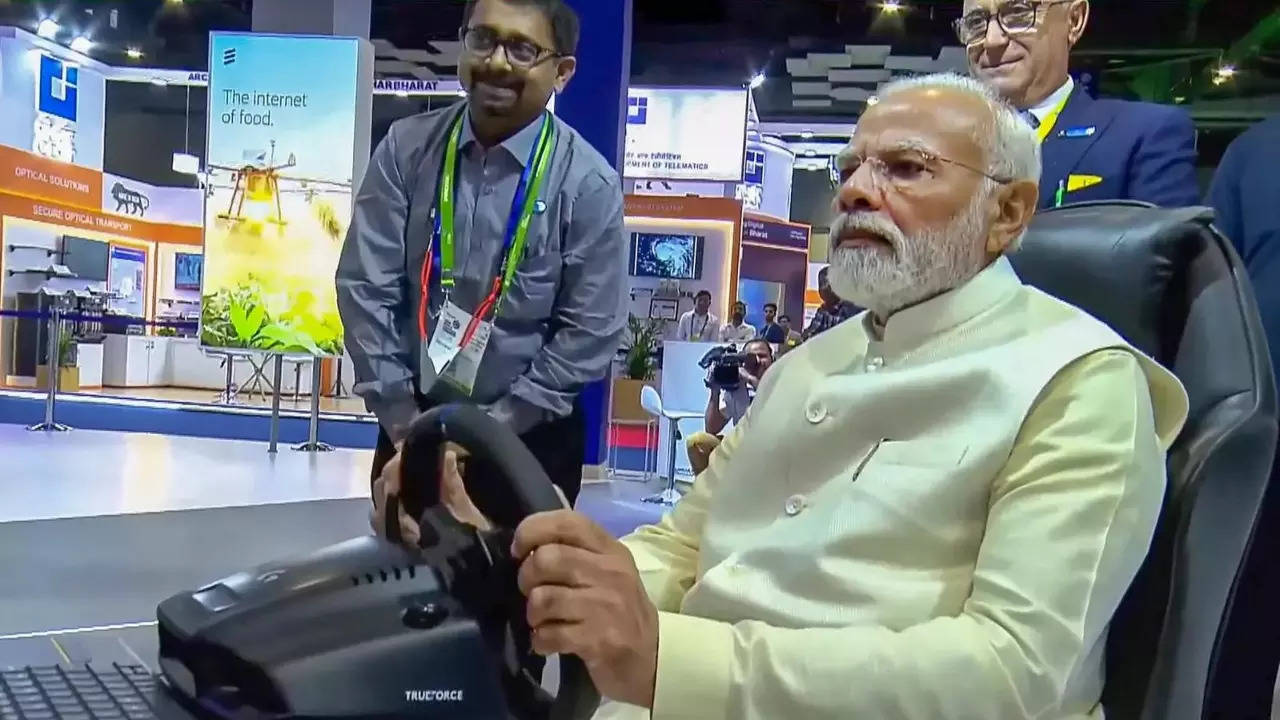 Prime Minister Narendra Modi drives a remote-controlled car at a stall during the inauguration of the 6th India Mobile Congress at Pragati Maidan in New Delhi. (PTI photo)
