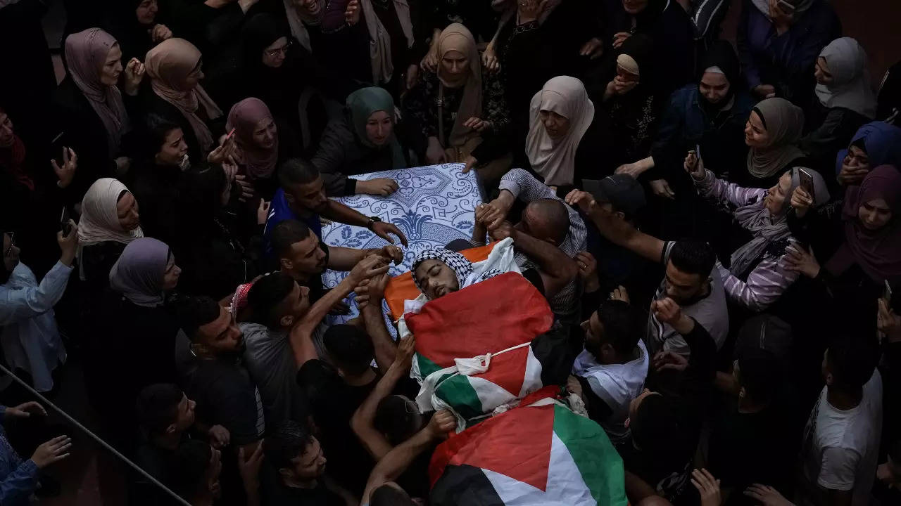 Palestinian mourners carry the body of Fayez Damdoum, during his funeral in the West Bank village of Azariyah, Saturday, October 1, 2022 (AP) 