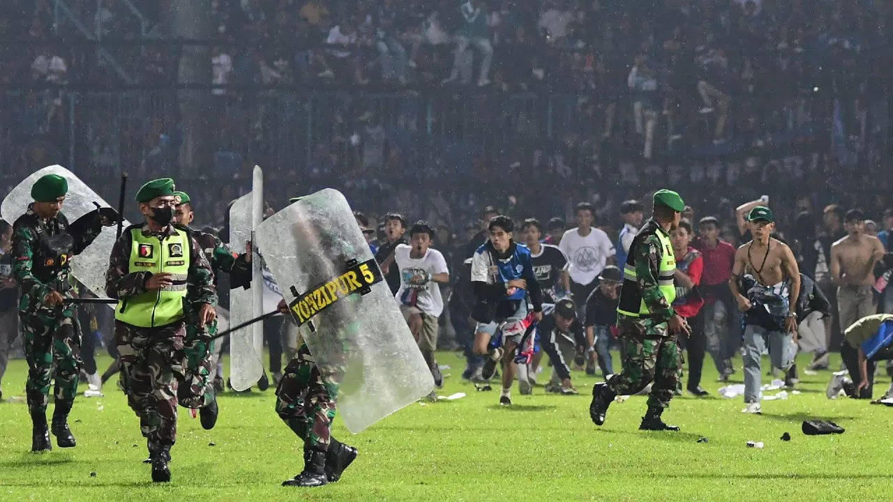 Arema FC supporters running on the pitch towards members of the Indonesian army after a football match at the Kanjuruhan stadium in Malang, East Java. (AFP photo)