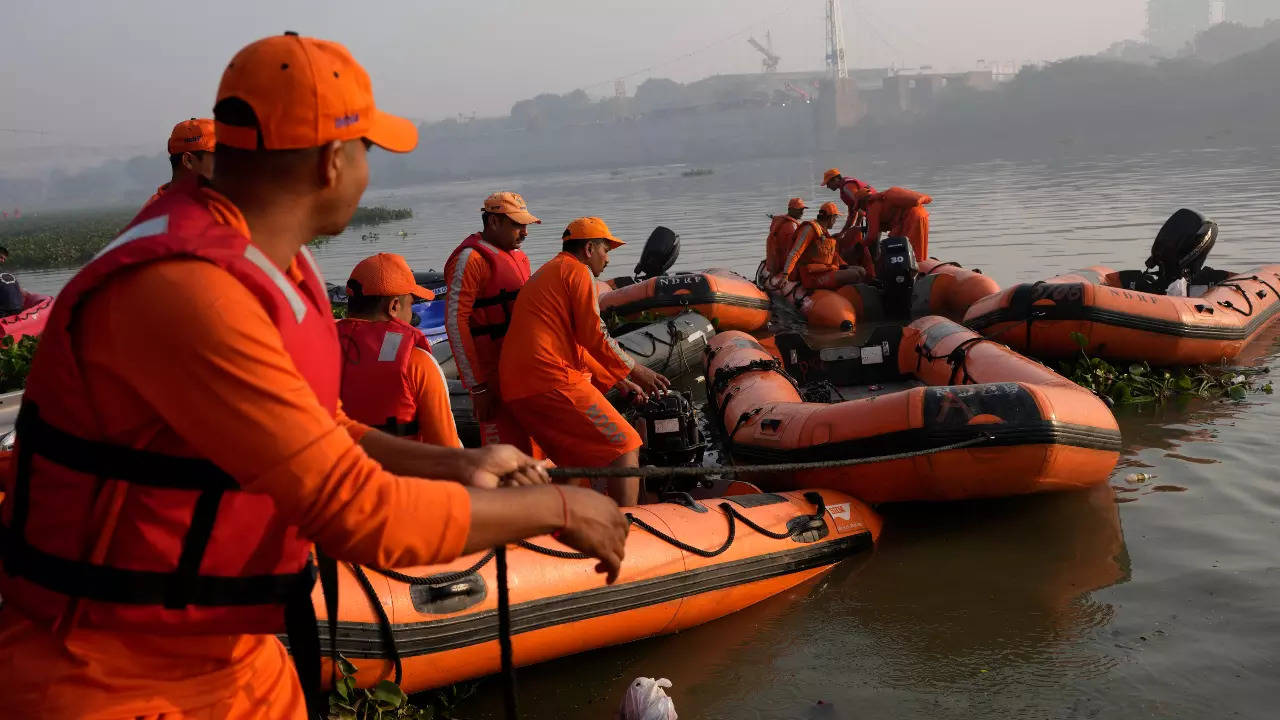 Rescuers prepare their boats for a search in the Machchu river where a pedestrian bridge collapsed on Sunday in Morbi, Gujarat 