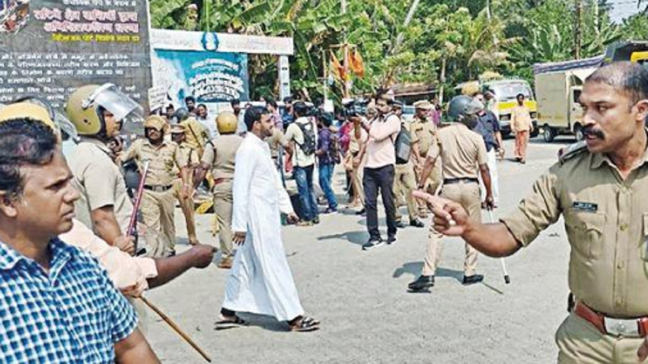 A police officer warns protesters amid clashes at Vizhinjam seaport site on Saturday