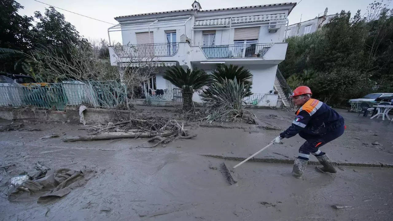 A man cleans mud and debris from a street after heavy rainfall triggered landslides in Casamicciola on the southern Italian island of Ischia, Sunday. (AP)