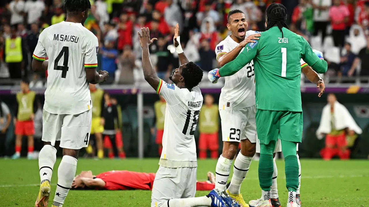 Daniel Amartey of Ghana prays while Ghana players celebrate their 3-2 victory in the FIFA World Cup match. (Getty Images)