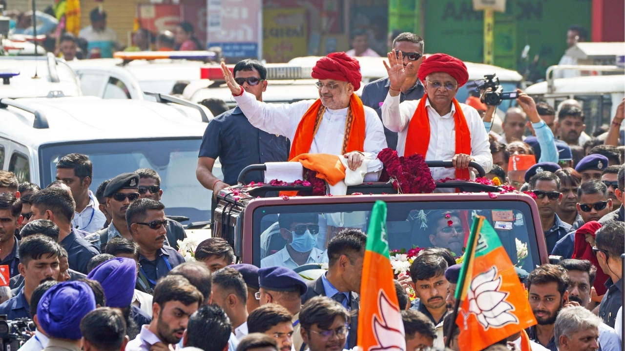 Union Home Minister Amit Shah and Gujarat CM Bhupendra Patel wave to the crowd during a roadshow in Ahmedabad (IANS)