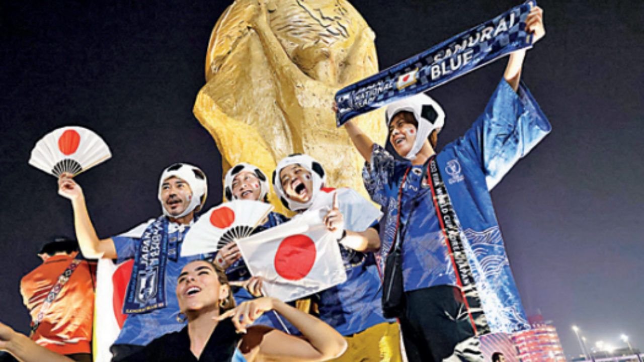 Japan fans celebrate outside the Khalifa International Stadium, Doha, after the match with Spain