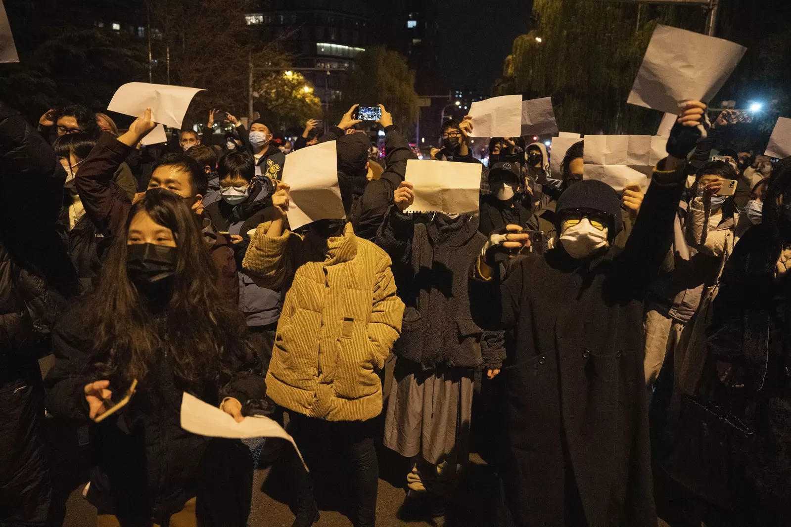 File photo: Protesters hold up blank papers and chant slogans as they march in protest in Beijing.