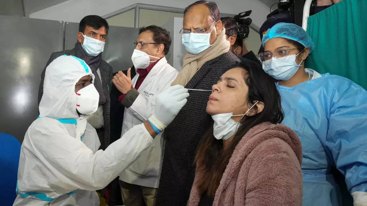 Union health minister Mansukh Mandaviya speaks with a doctor as a medic collects swab sample of a woman, during a nationwide mock drill for Covid-19 preparedness, at Safdarjung hospital in New Delhi on Tuesday. (PTI photo)